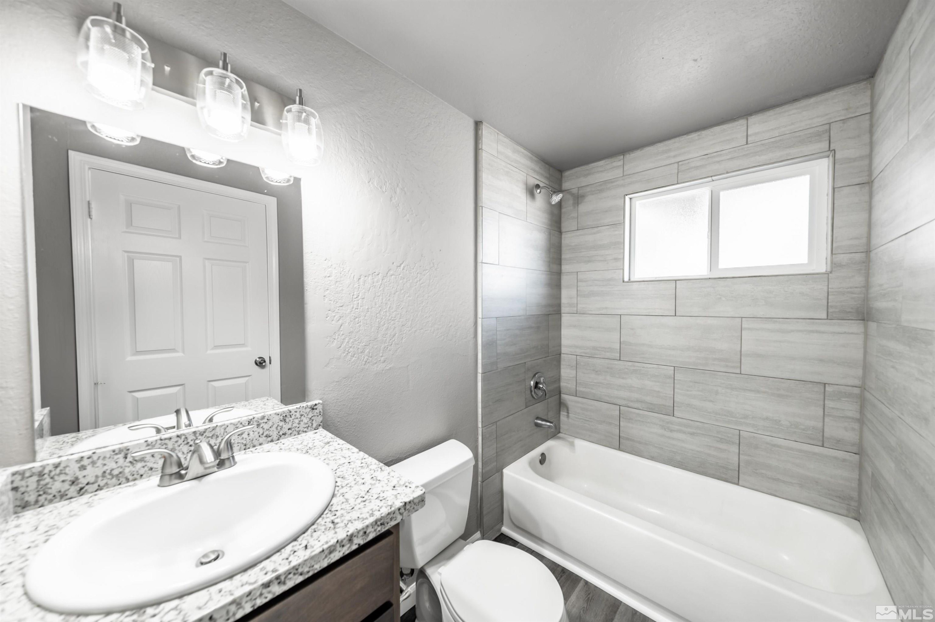 495 Kess Court Reno, NV 89506 - Photo 10 of 18 a bathroom with a granite countertop sink toilet and shower