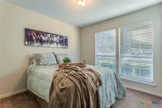 a bed sitting in a bedroom next to a window