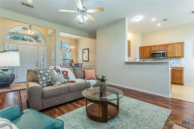 a living room with furniture and a wooden floor