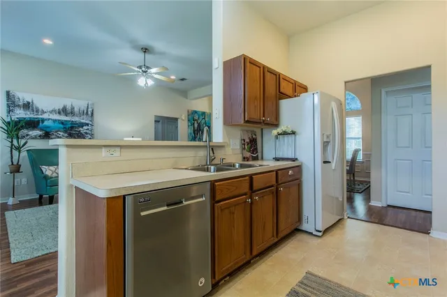 a kitchen with a sink a refrigerator and cabinets