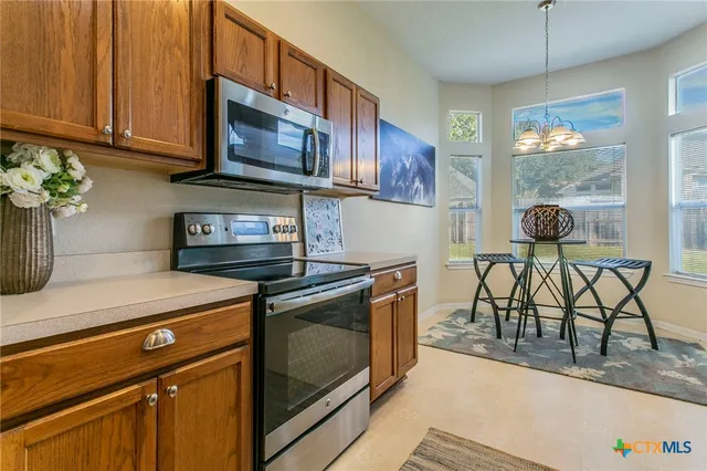 a kitchen with stainless steel appliances granite countertop a stove a microwave a sink and cabinets