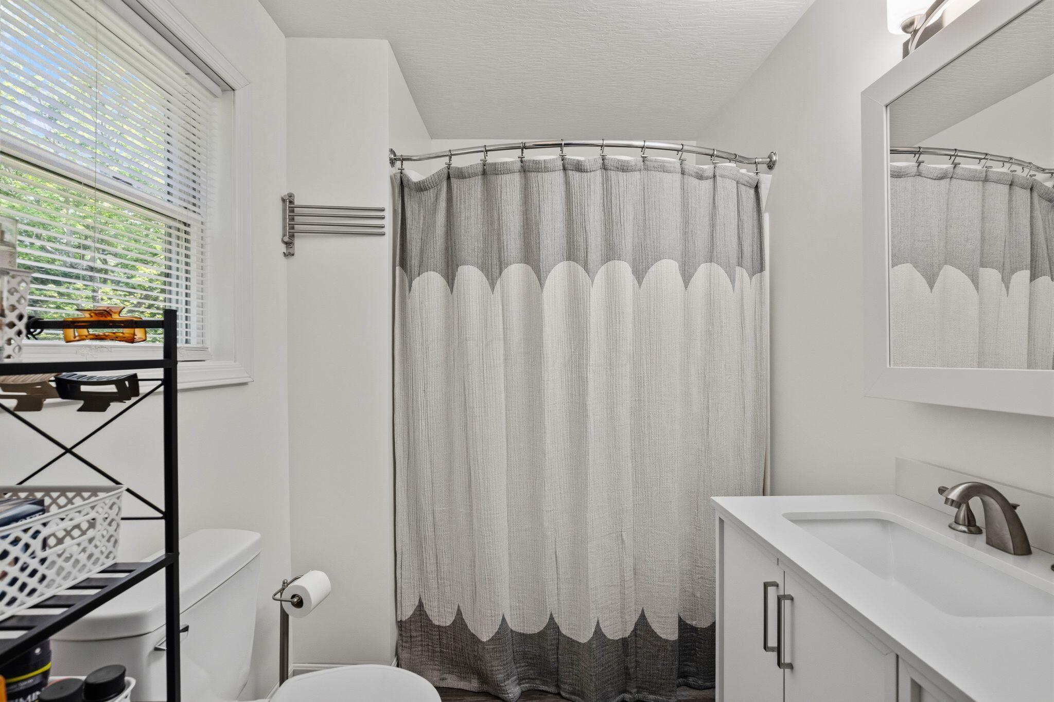 10446 Rich Hollow Road Southwest Lancaster, OH 43130 - Photo 49 of 83 Bathroom featuring a shower with curved rod, white vanity with integrated sink, brushed nickel faucet, and framed mirror