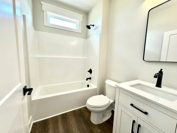 a bathroom with a toilet a sink a mirror and bathtub