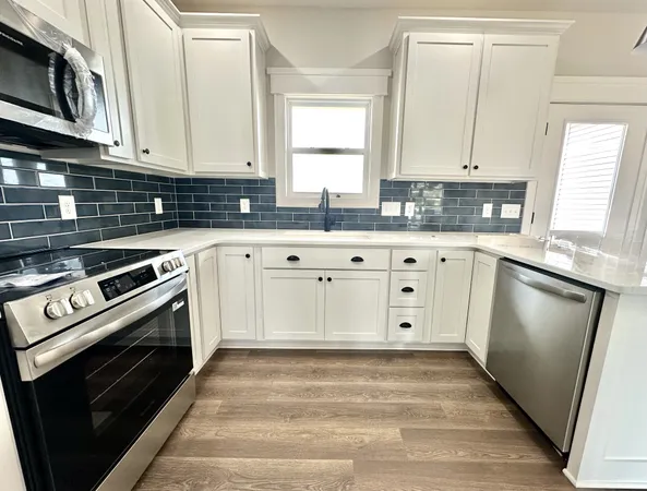 a kitchen with stainless steel appliances granite countertop a stove a sink and a microwave