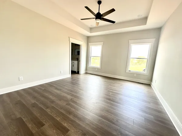 a view of an empty room with window and wooden floor