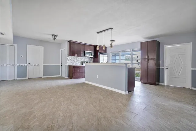 a view of a kitchen with a refrigerator a microwave and a sink