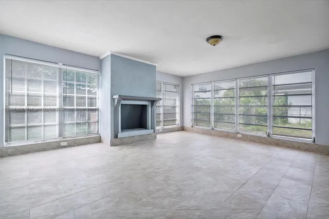 a view of an empty room with a fireplace and a large window