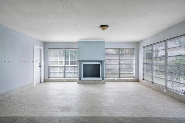 an empty room with a fireplace and window
