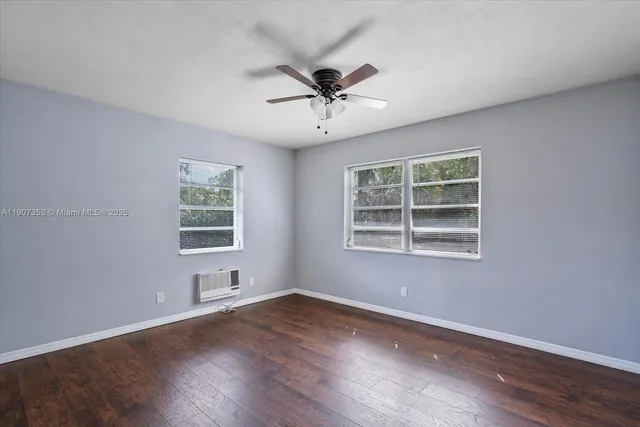 a view of wooden floor and windows in a room