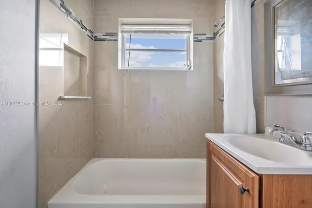 a bathroom with a sink a mirror and a bathtub