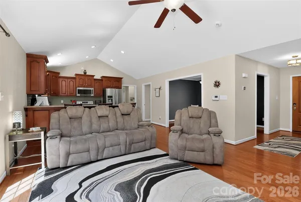 a kitchen with stainless steel appliances a refrigerator a stove a sink a dining table and chairs