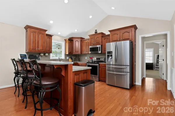 a kitchen with stainless steel appliances granite countertop a stove a sink dishwasher a refrigerator and a oven