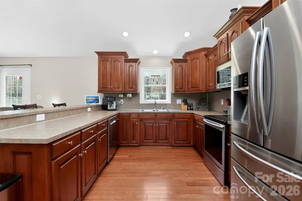 a kitchen with stainless steel appliances granite countertop a sink stove and microwave