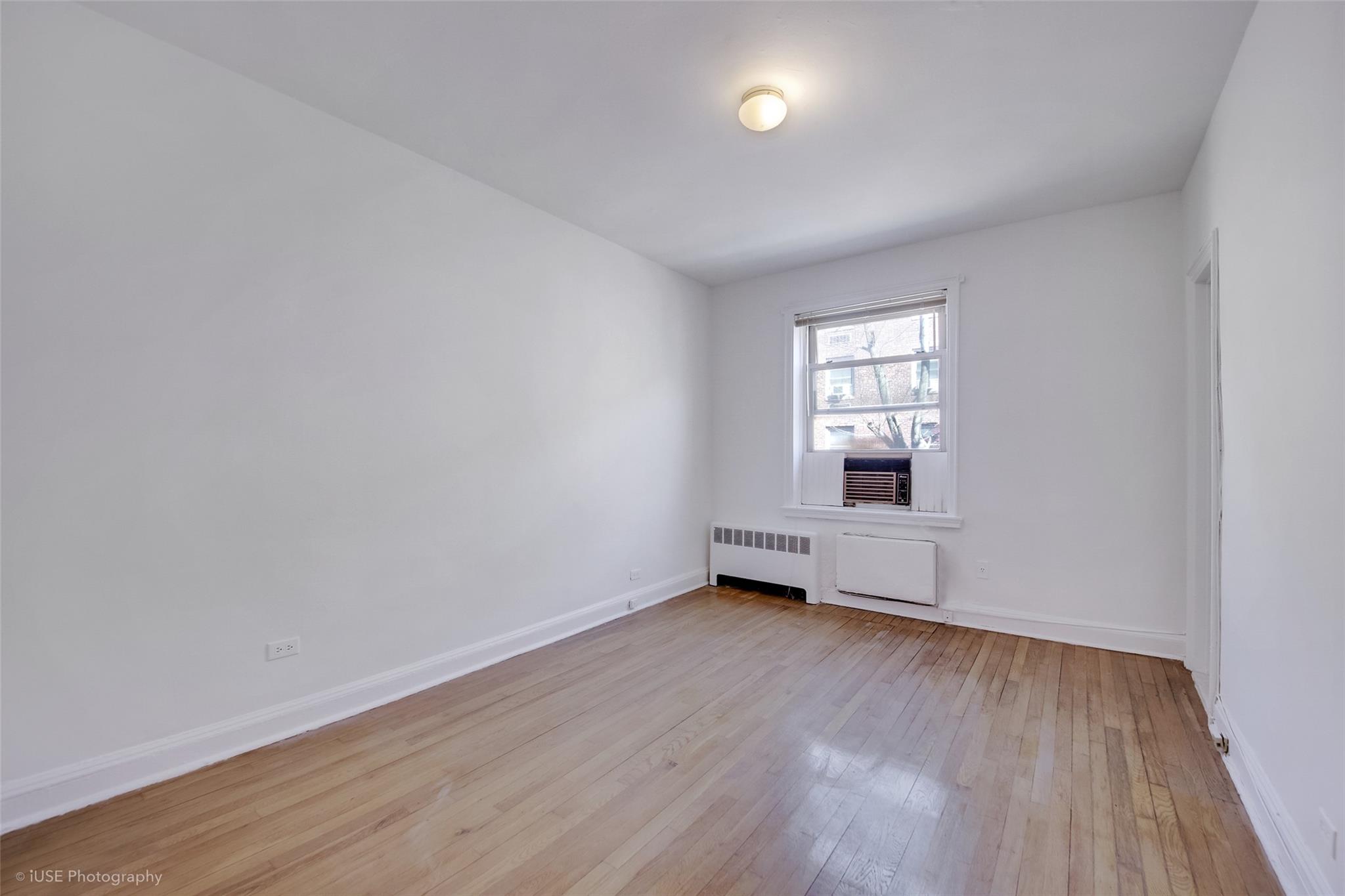 48-41 43rd Street, Unit 5F Queens, NY 11377 - Photo 5 of 8 an empty room with wooden floor and windows