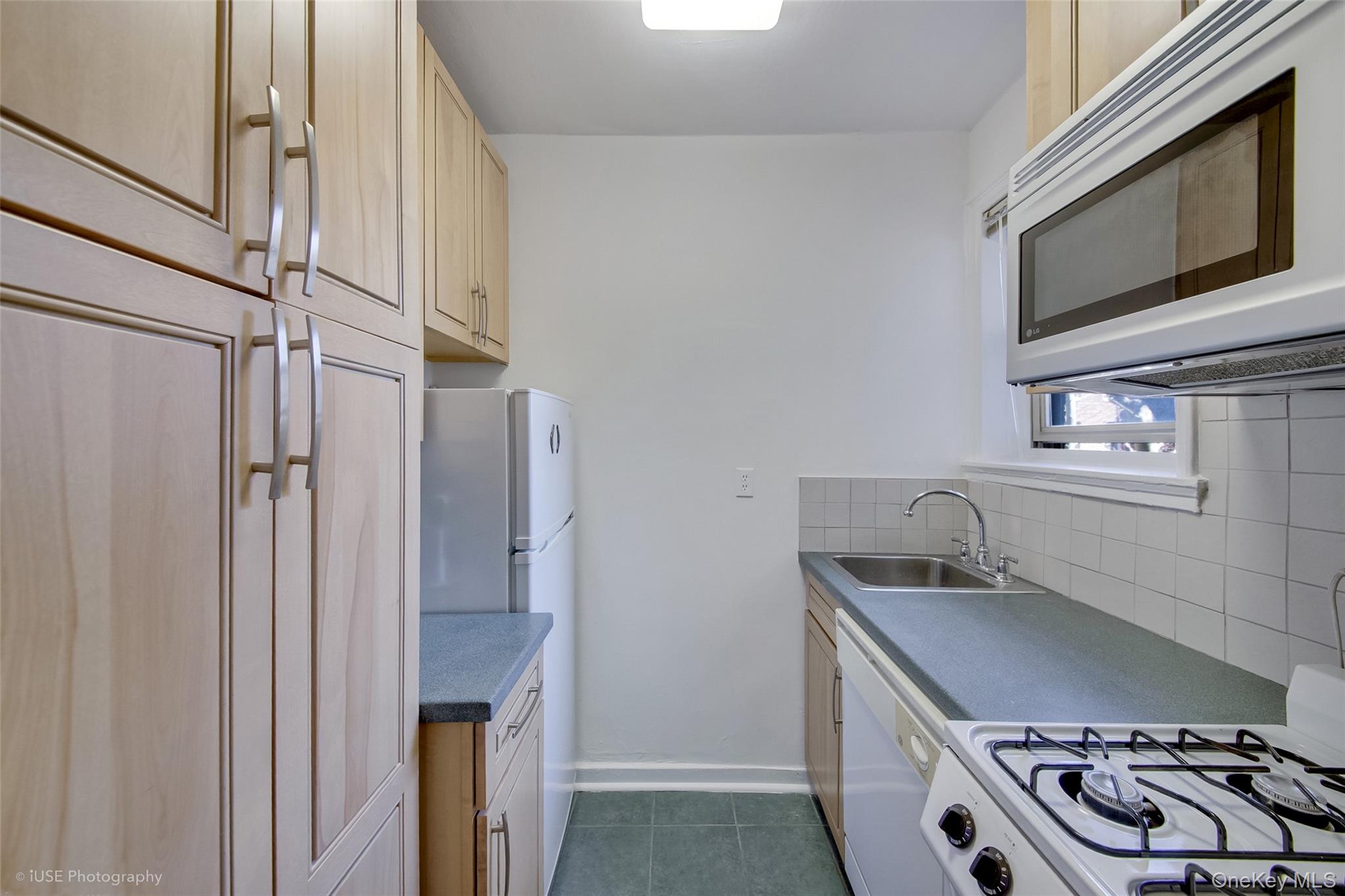48-41 43rd Street, Unit 5F Queens, NY 11377 - Photo 6 of 8 a kitchen with stainless steel appliances granite countertop a sink stove and refrigerator