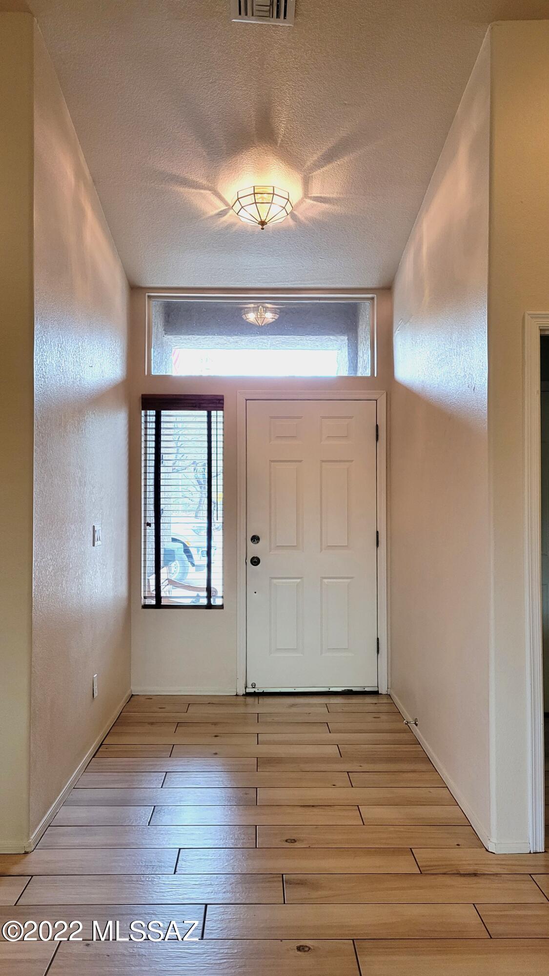293 Valley View Drive Rio Rico, AZ 85648 - Photo 4 of 38 an empty room with wooden floor and windows