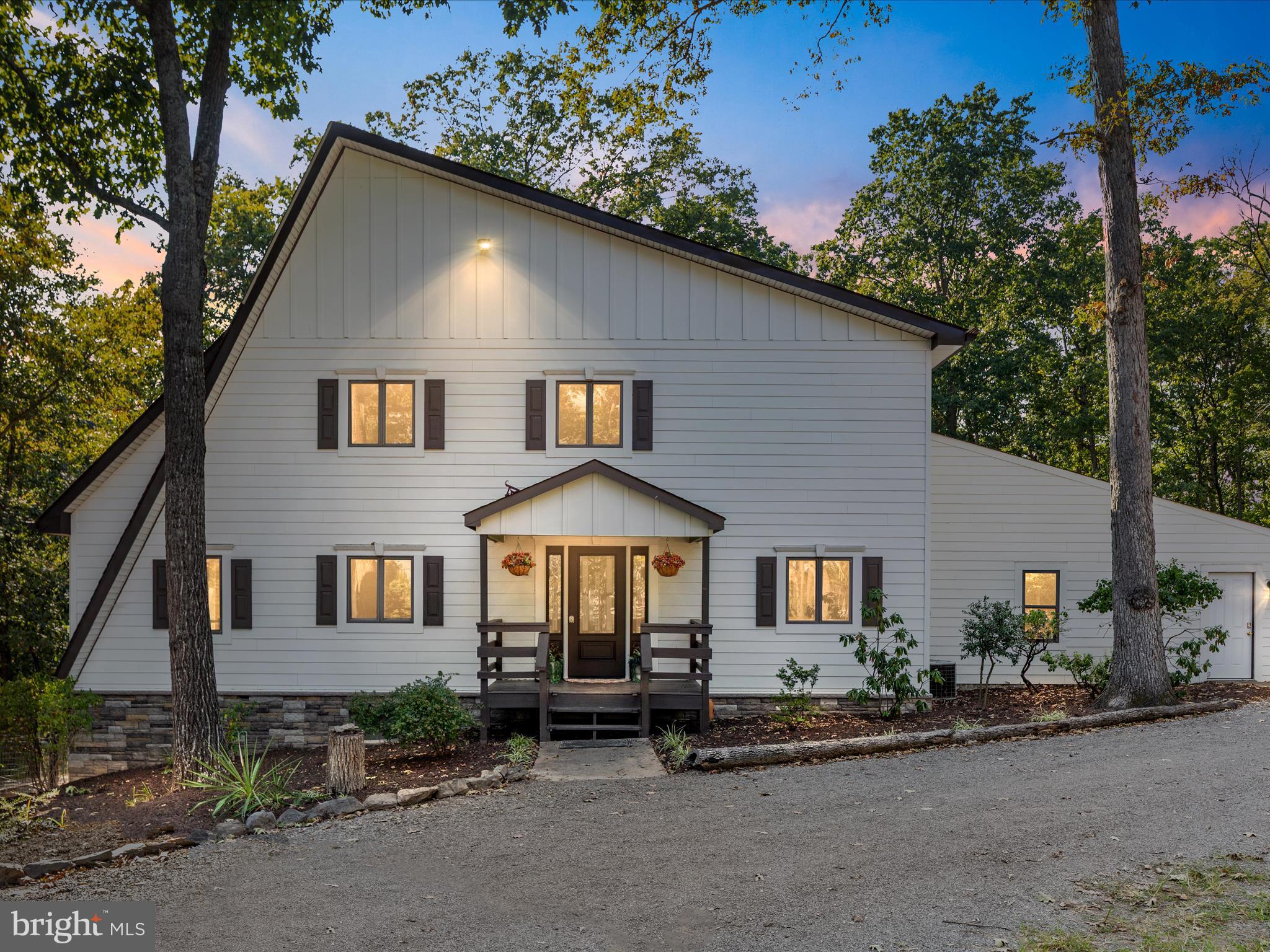 a front view of a house with yard and parking