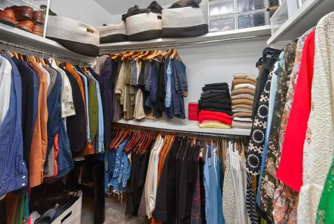 a view of walk in closet with clothes and shoes