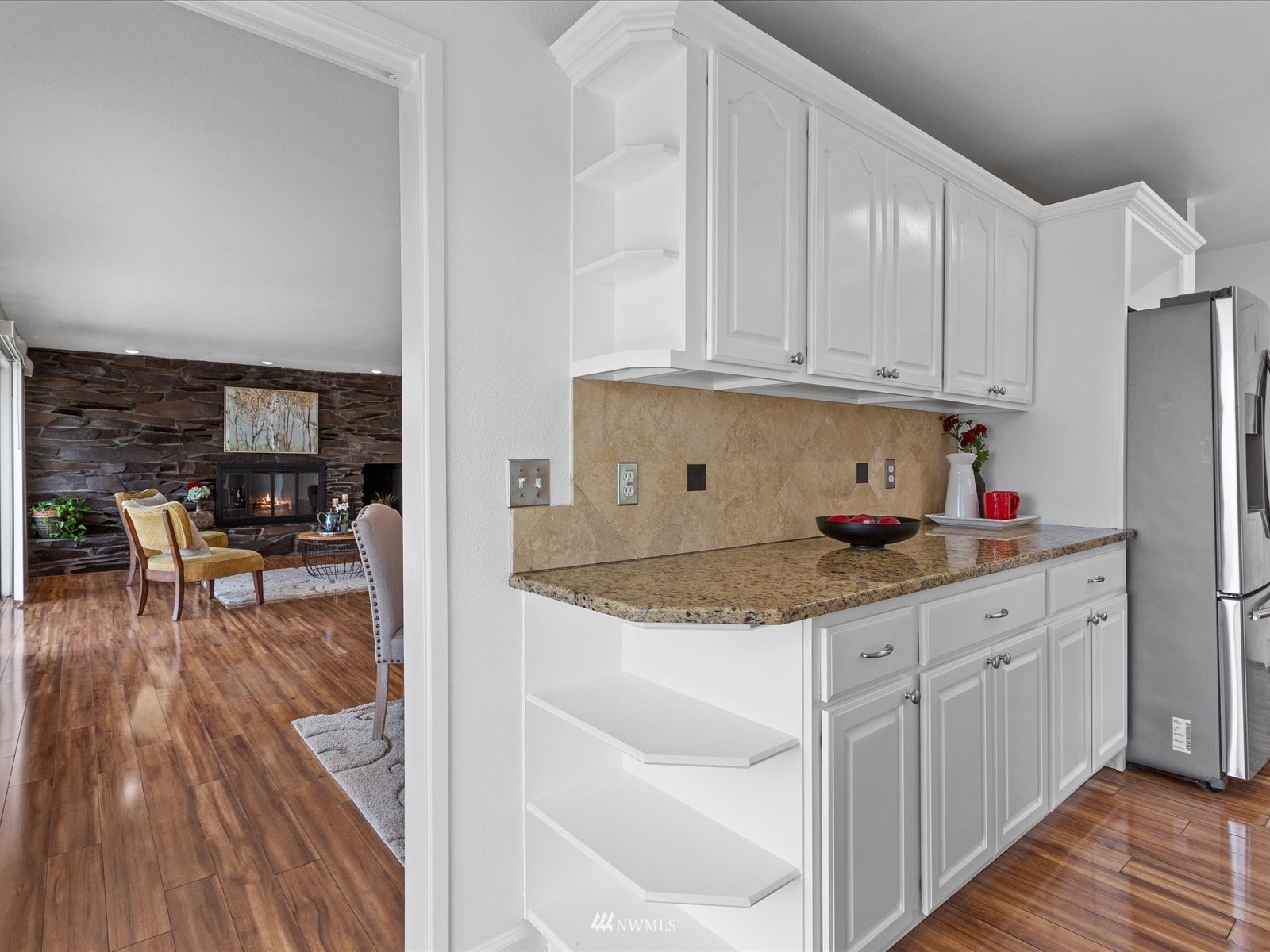18156 Riviera Place Southwest Normandy Park, WA 98166 - Photo 9 of 40 a kitchen with granite countertop wooden cabinets a dining table and chairs
