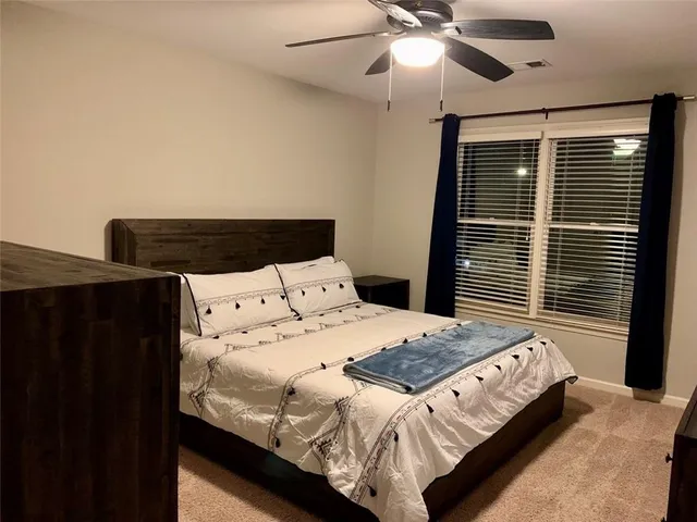 a bedroom with a bed and a ceiling fan