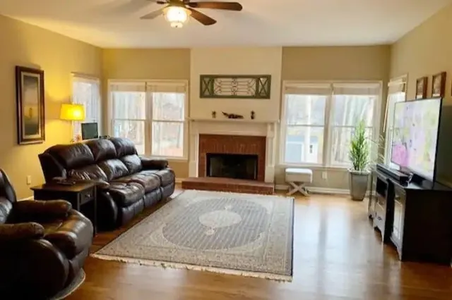 a living room with furniture a flat screen tv and a fireplace