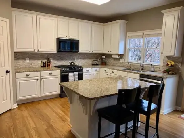 a kitchen with stainless steel appliances granite countertop a stove a sink dishwasher and a refrigerator with wooden floor