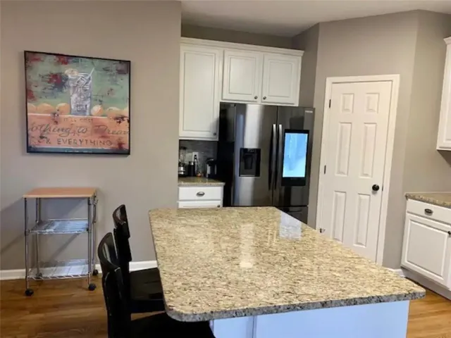 a view of kitchen island with cabinets and wooden floor