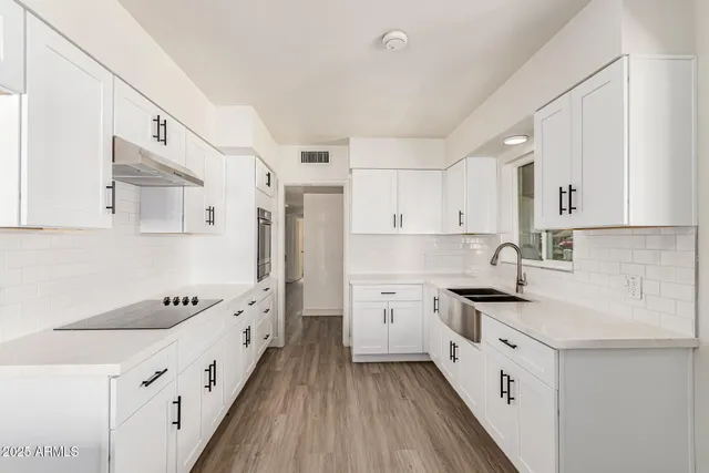 a kitchen with stainless steel appliances sink stove top oven and cabinets
