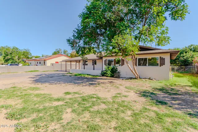 a view of a house with backyard and trees