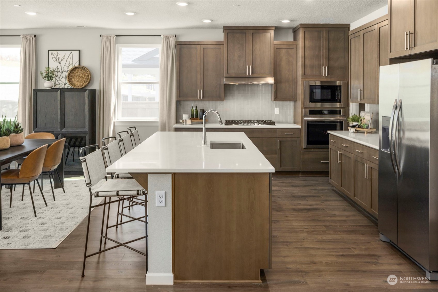 2814 South 9th Avenue Ridgefield, WA 98642 - Photo 4 of 37 a kitchen with stainless steel appliances kitchen island granite countertop a refrigerator a stove top oven and a sink with wooden floor