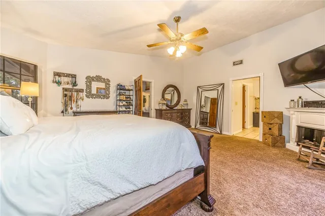 a spacious bedroom with a bed and a flat screen tv