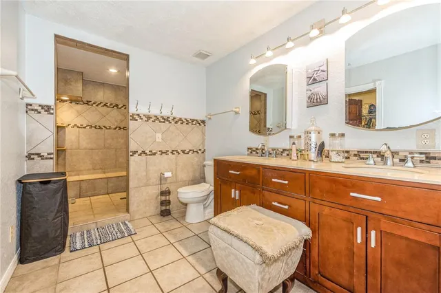 a spacious bathroom with a double vanity sink toilet and shower