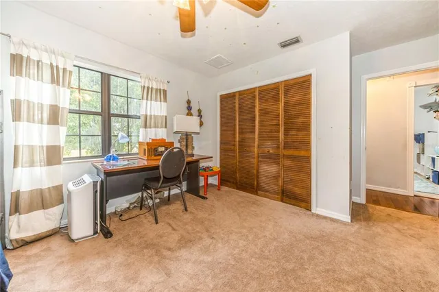 a view of a workspace with furniture and a window