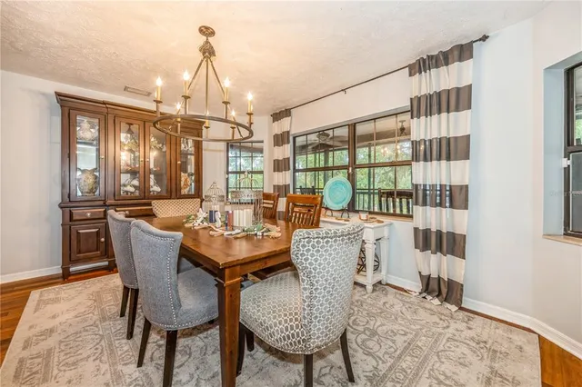 a dining room with furniture a chandelier and wooden floor