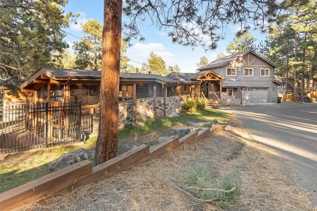 a front view of a house with a yard and trees