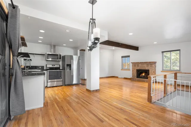 a kitchen with refrigerator and wooden floor
