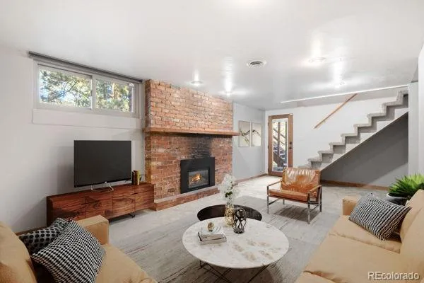 a living room with furniture a fireplace and a flat screen tv