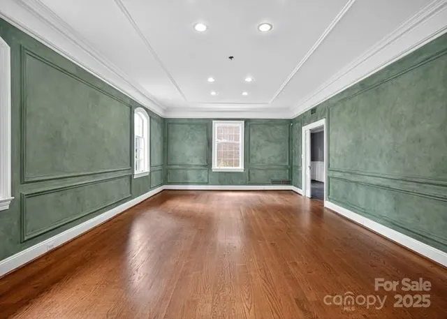 a view of empty room with wooden floor