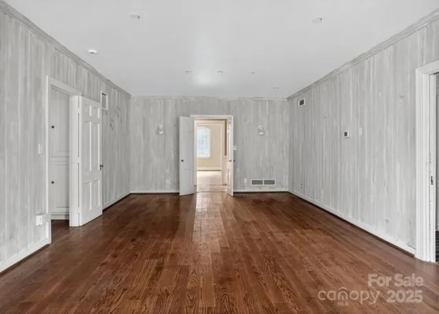 a view of an empty room with wooden floor