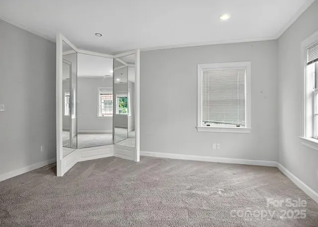 an empty room with windows and closet