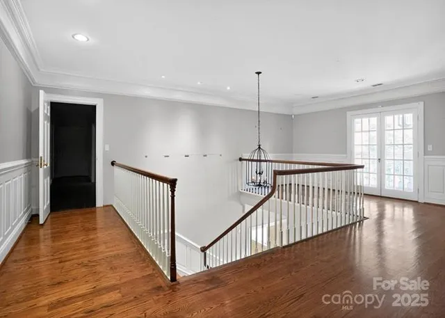 a view of a hallway with wooden floor and windows