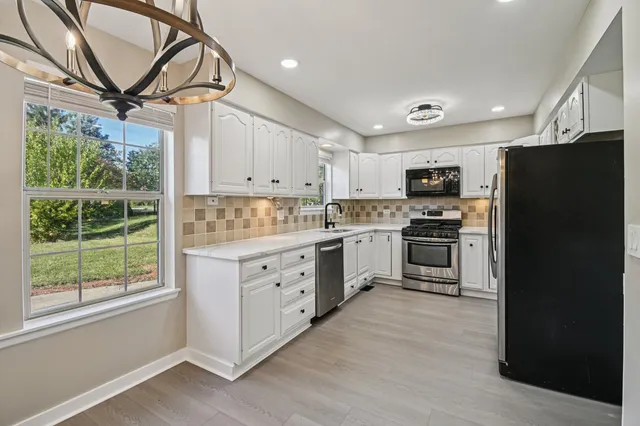 a kitchen with kitchen island white cabinets and refrigerator