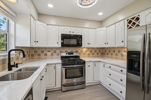 a kitchen with white cabinets and stainless steel appliances