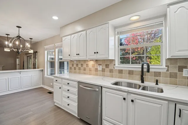 a kitchen with granite countertop white cabinets and window