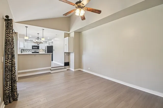 a view of a kitchen with wooden floor and a ceiling fan