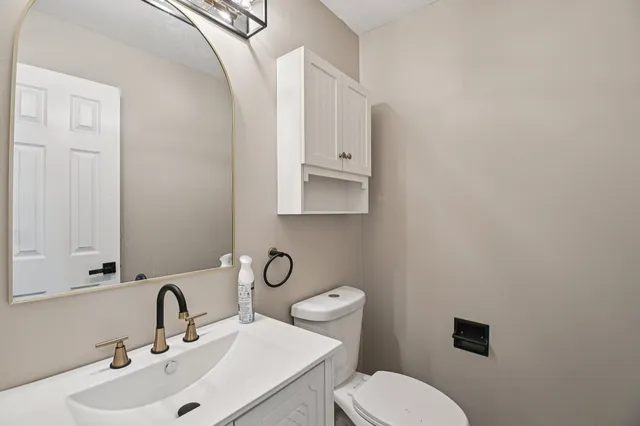 a bathroom with a toilet sink and mirror