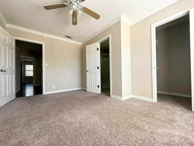 a view of an empty room with a ceiling fan
