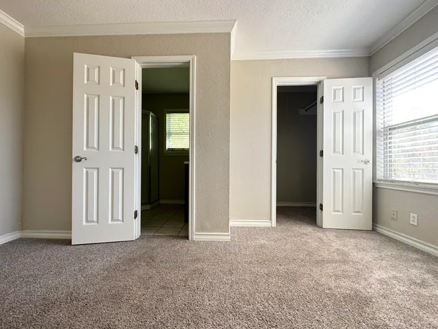 an empty room with windows and closet