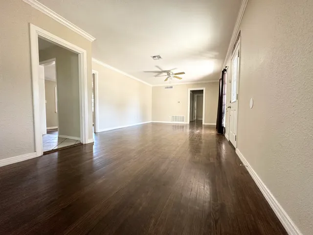 an empty room with wooden floor and workspace