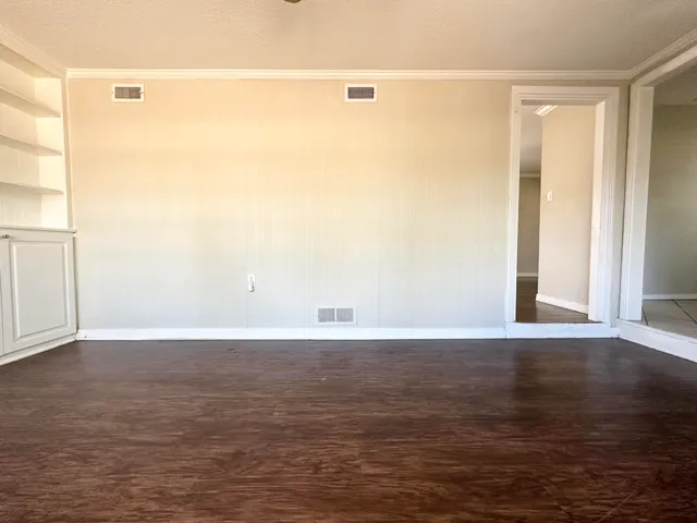 a view of an empty room with wooden floor